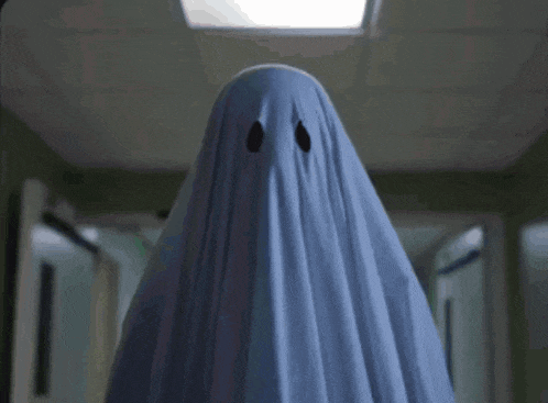 a person dressed as a ghost with a blue sheet over their head .