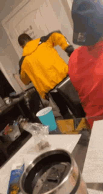 a man in a yellow jacket is standing next to a man in a red jacket