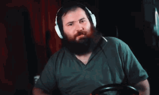 a man with a beard wearing headphones is pointing