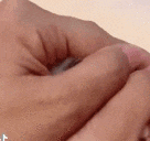 a close up of a person 's hand holding a bottle of liquid .