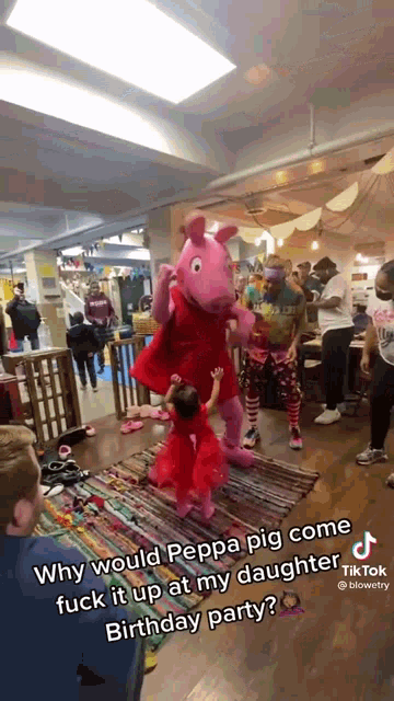 a little girl standing next to a peppa pig mascot at a birthday party .