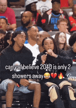 a group of people sitting in a stadium with a caption that says " can yall believe 2040 is only 2 showers away