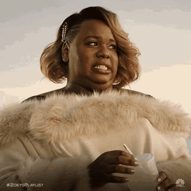 a woman in a fur coat is holding a cup with a straw