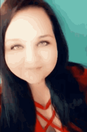 a woman with long black hair and green eyes is smiling