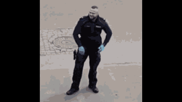 a police officer wearing blue gloves is dancing on a street