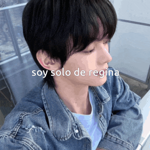 a man in a denim jacket has the words soy solo de regina written on his face