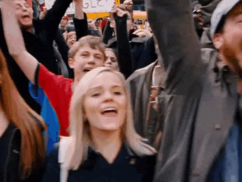 a crowd of people with their arms in the air and a sign that says " glc "