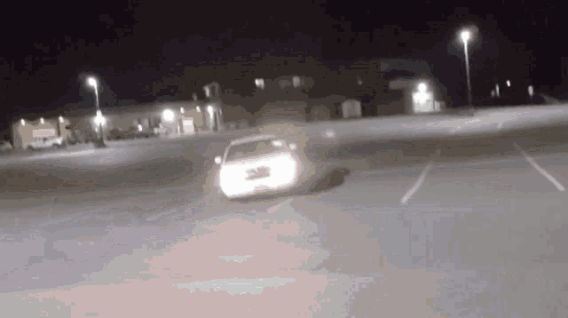 a car is driving down a parking lot at night with a license plate that says ' a ' on it