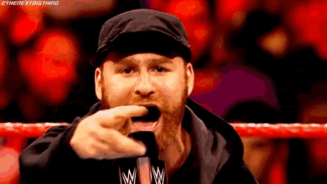 a man with a beard is screaming in a wrestling ring with the next big thing written on the bottom of the image
