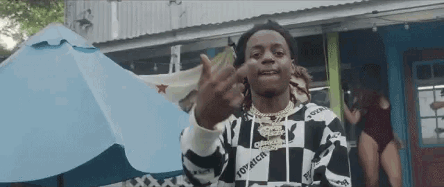 a man in a checkered shirt is giving the middle finger .