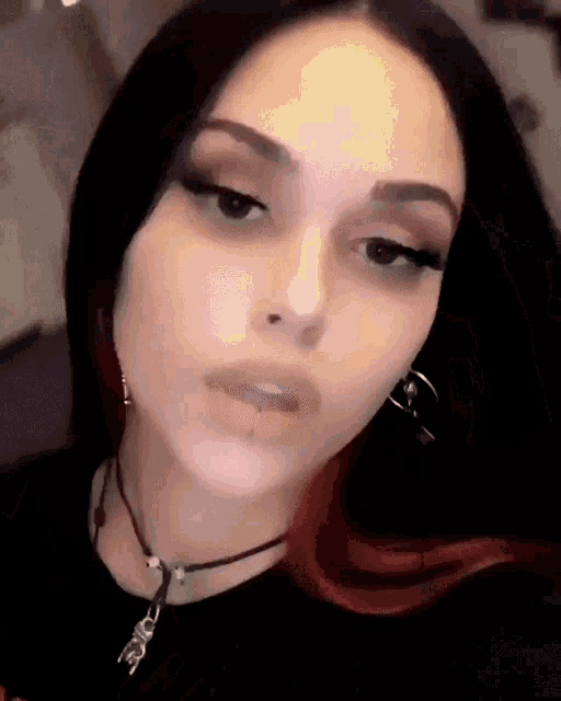 a close up of a woman 's face with a necklace and earrings