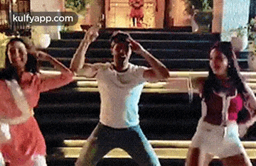 a man and two women are dancing together in front of a building .