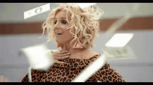 a woman in a leopard print dress is standing in front of a wall of money .