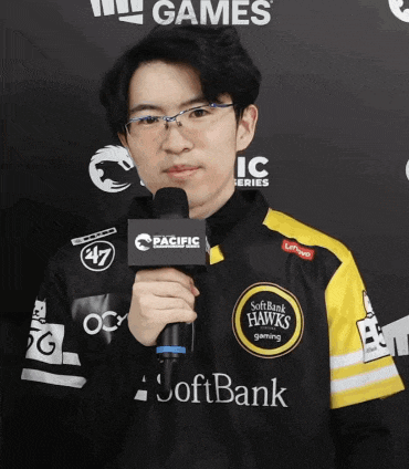 a man holding a microphone with softbank written on his shirt