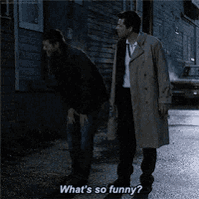 a man in a trench coat says " what 's so funny " while standing next to another man