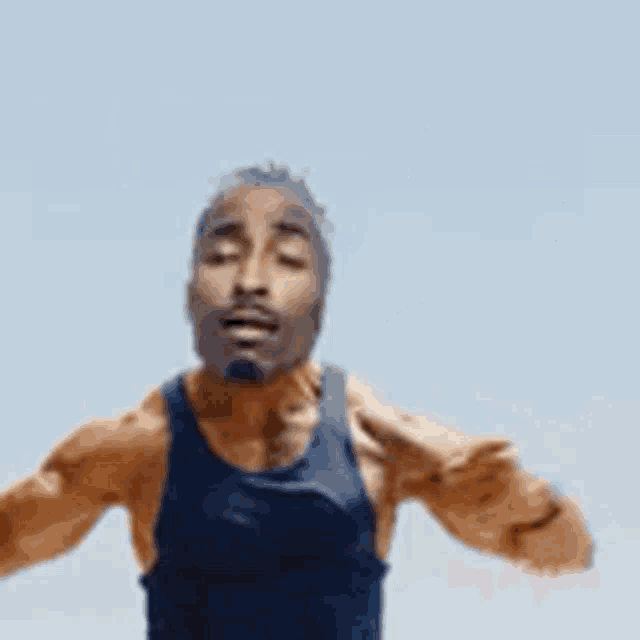 a man with a beard is wearing a black tank top and a watch .