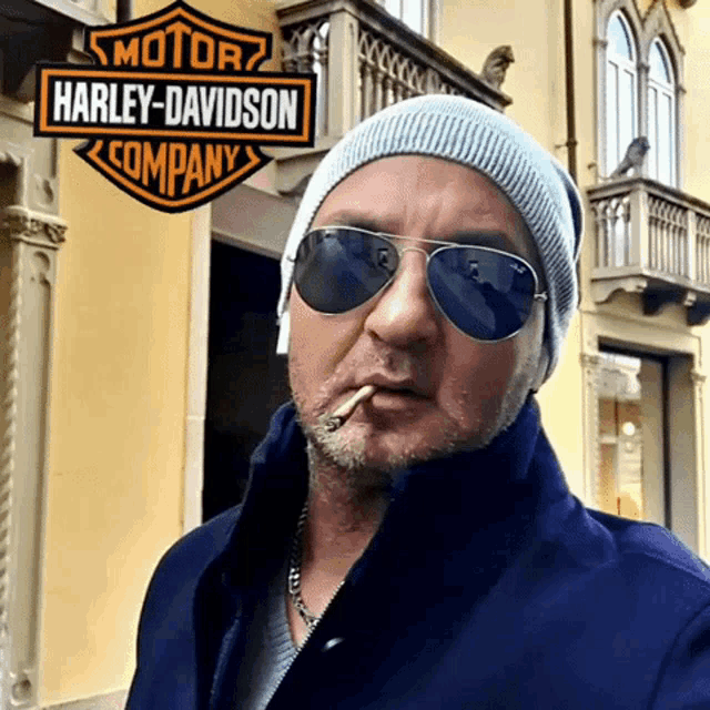a man smoking a cigarette in front of a harley davidson logo