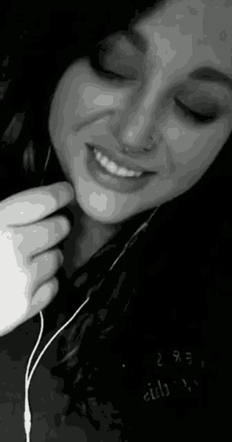 a black and white photo of a woman with a nose ring and headphones