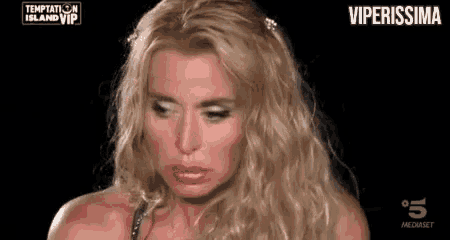 a woman with long blonde hair is making a funny face .
