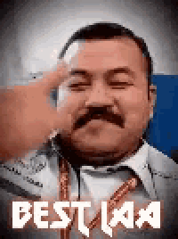 a man with a mustache is making a peace sign with his finger .