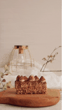 a piece of cake on a wooden cutting board with the words venha cortar o bolo