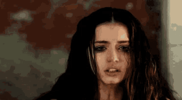 a close up of a woman 's face with tears running down her cheeks .