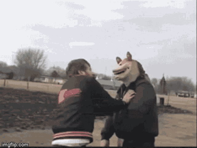 a man in a horse mask is fighting another man in a black jacket