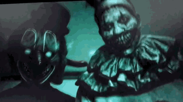 two scary clowns are standing next to each other in a dark room with glowing eyes .