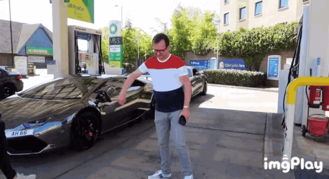 a man is standing in front of a car at a bp gas station