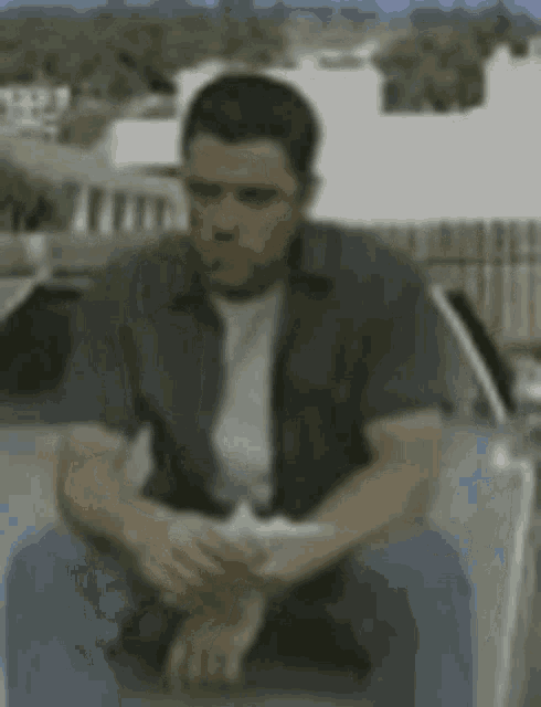 a man is sitting on the back of a car holding a piece of paper .
