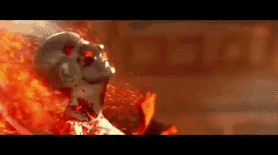 a skull is surrounded by flames and blood in a dark room .
