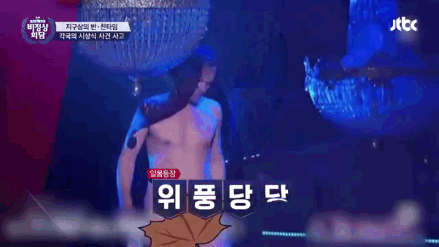 a man without a shirt is on a stage in front of a jtbc sign