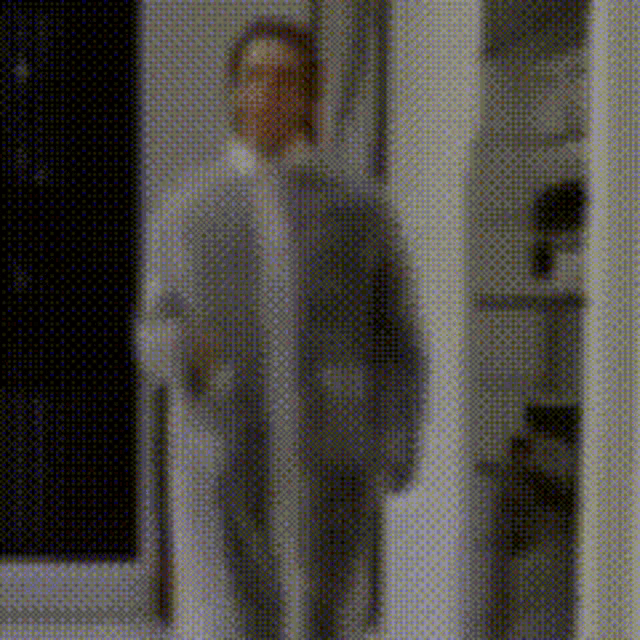 a blurred image of a man in a suit standing in a doorway .