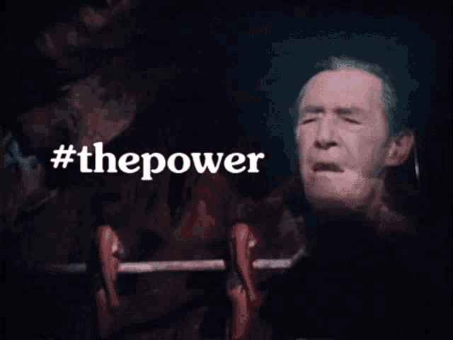 a man is in a dark room with the words #thepower behind him