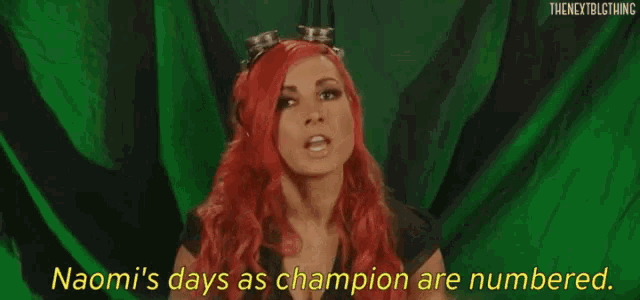 a woman with red hair is standing in front of a green curtain and says `` naomi 's days as champion are numbered ''