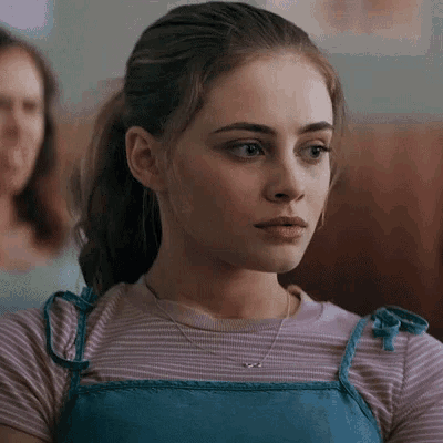 a close up of a woman wearing a striped shirt and a blue dress