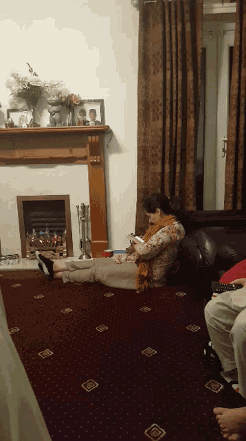 a woman is laying on the floor looking at her phone