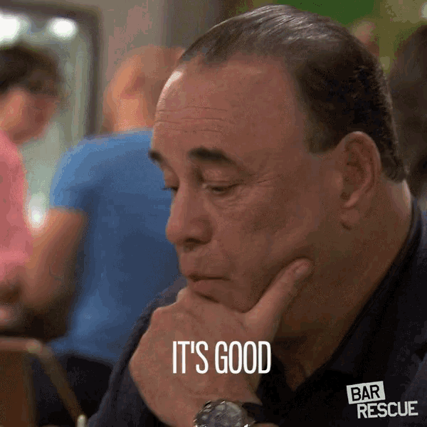 a man sitting at a table with his hand on his chin and the words it 's good above him