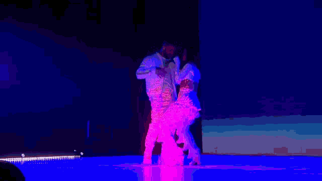 a man and a woman are singing into microphones while standing next to each other on a stage .
