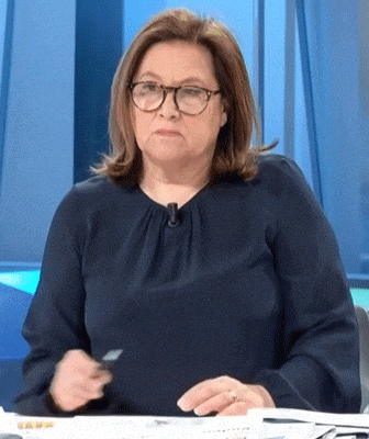 a woman wearing glasses and a blue shirt is sitting at a desk