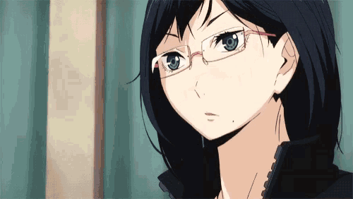 a close up of a girl wearing glasses looking at the camera .