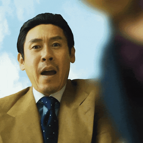 a man in a suit and tie is making a funny face