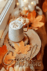 a cup of coffee is sitting on a wooden table next to autumn leaves .