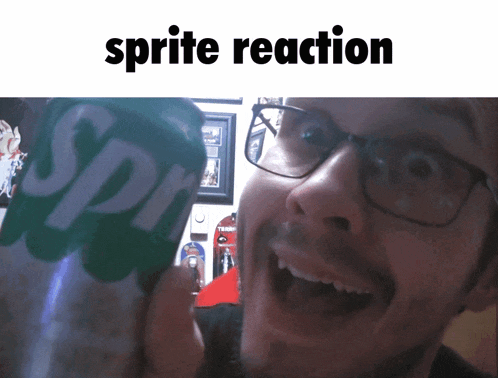 a man with glasses holds a can of sprite in front of his face
