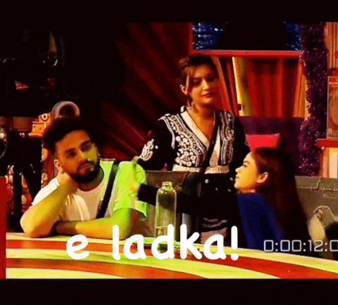 a man and a woman are sitting at a table with the words e ladka written on the bottom
