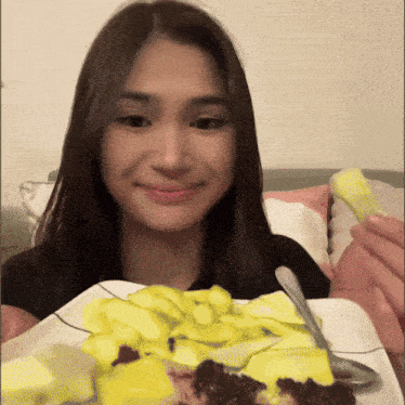 a woman is eating a plate of food with a spoon in her hand