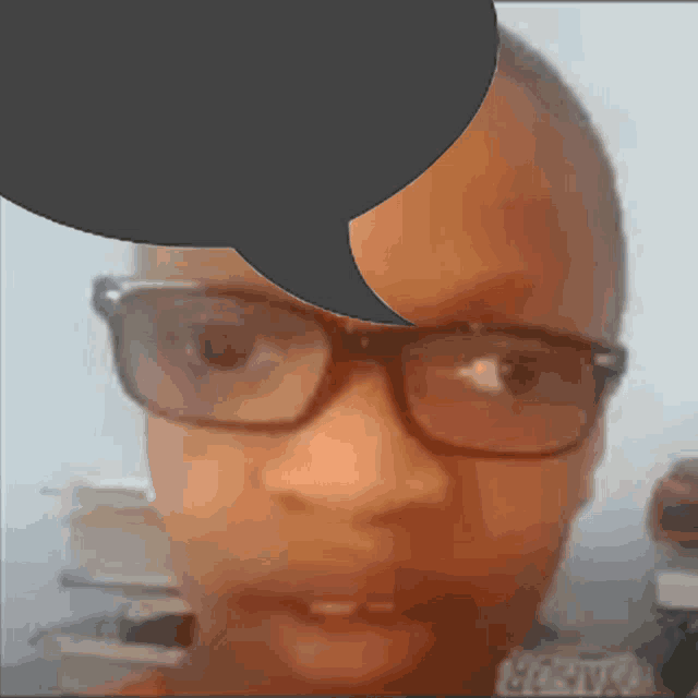 a person wearing glasses has a speech bubble over their head