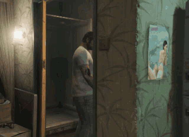 a man standing in a room with a picture of a woman on the wall that says ' venus ' on it