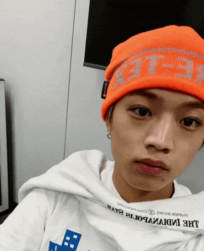 a person wearing an orange beanie that says " flex "