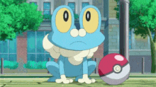 a blue frog with yellow eyes is sitting next to a pokeball